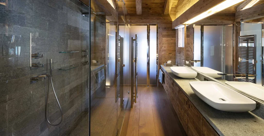 Salle de bains de chalet réalisée par Carroz SA — douche et vasques sur mesure