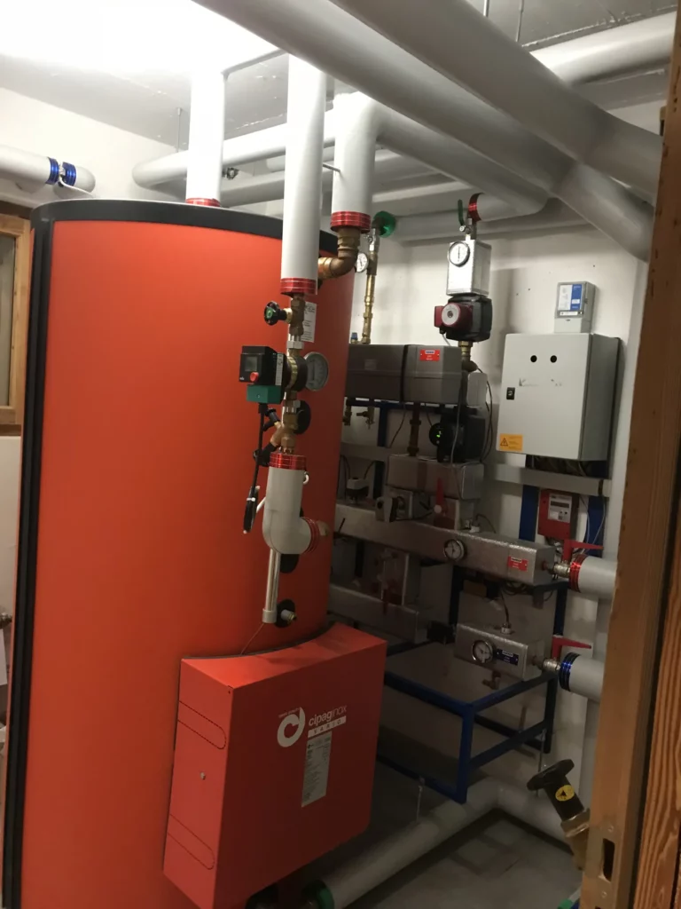 Chaufferie avec accumulateur rouge et distribution de chauffage
